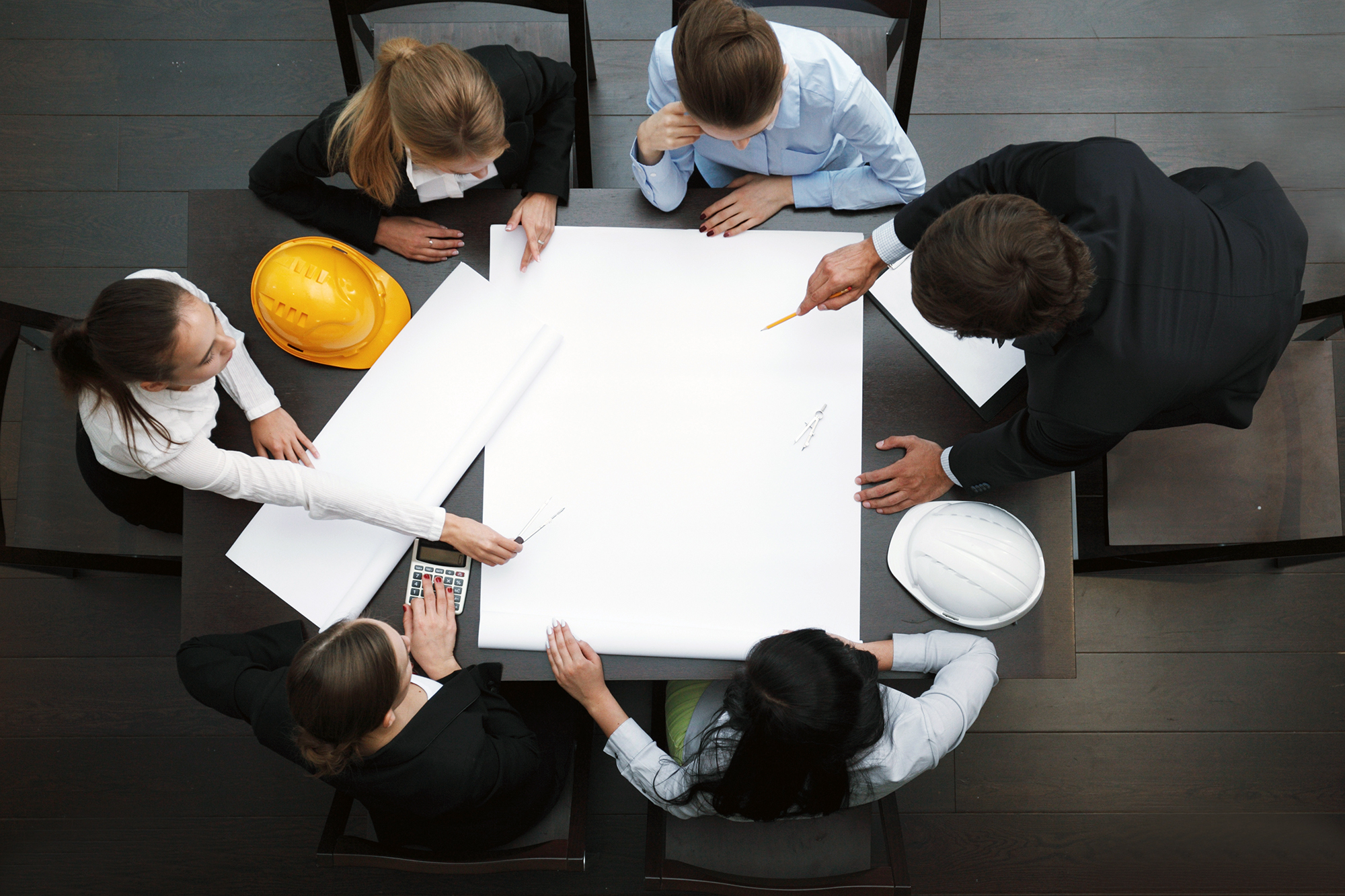 Construction workers around a blueprint