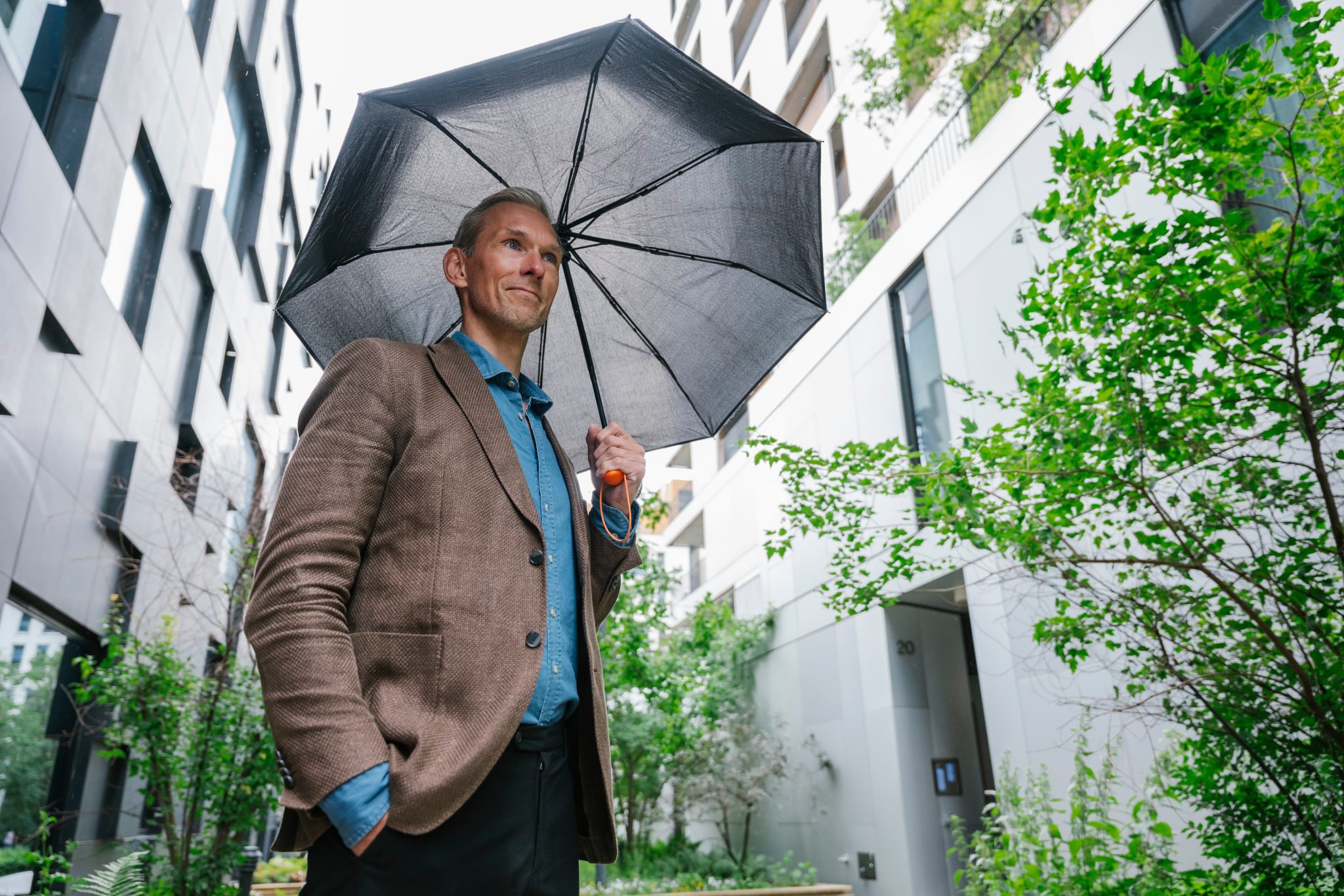 Kenneth Ryvoll Klev i Assessit står med en paraply. Foto
