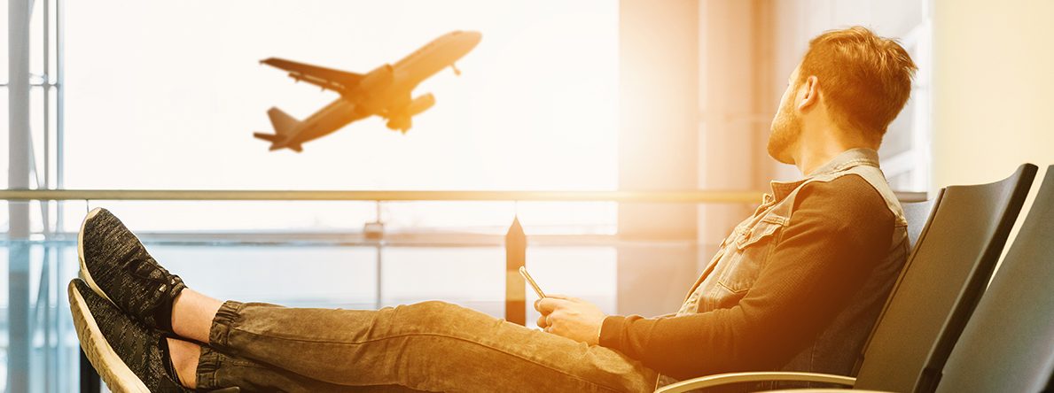 En mann sitter på en flyplass. Foto
