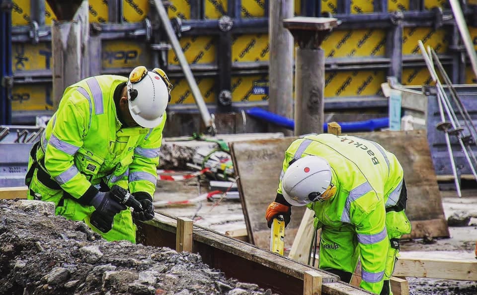 To arbeidere p&aring; en byggeplass. Foto