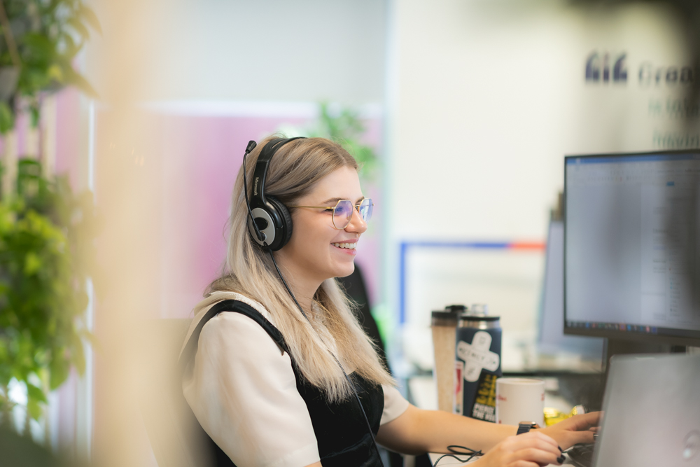 women on headset at desk