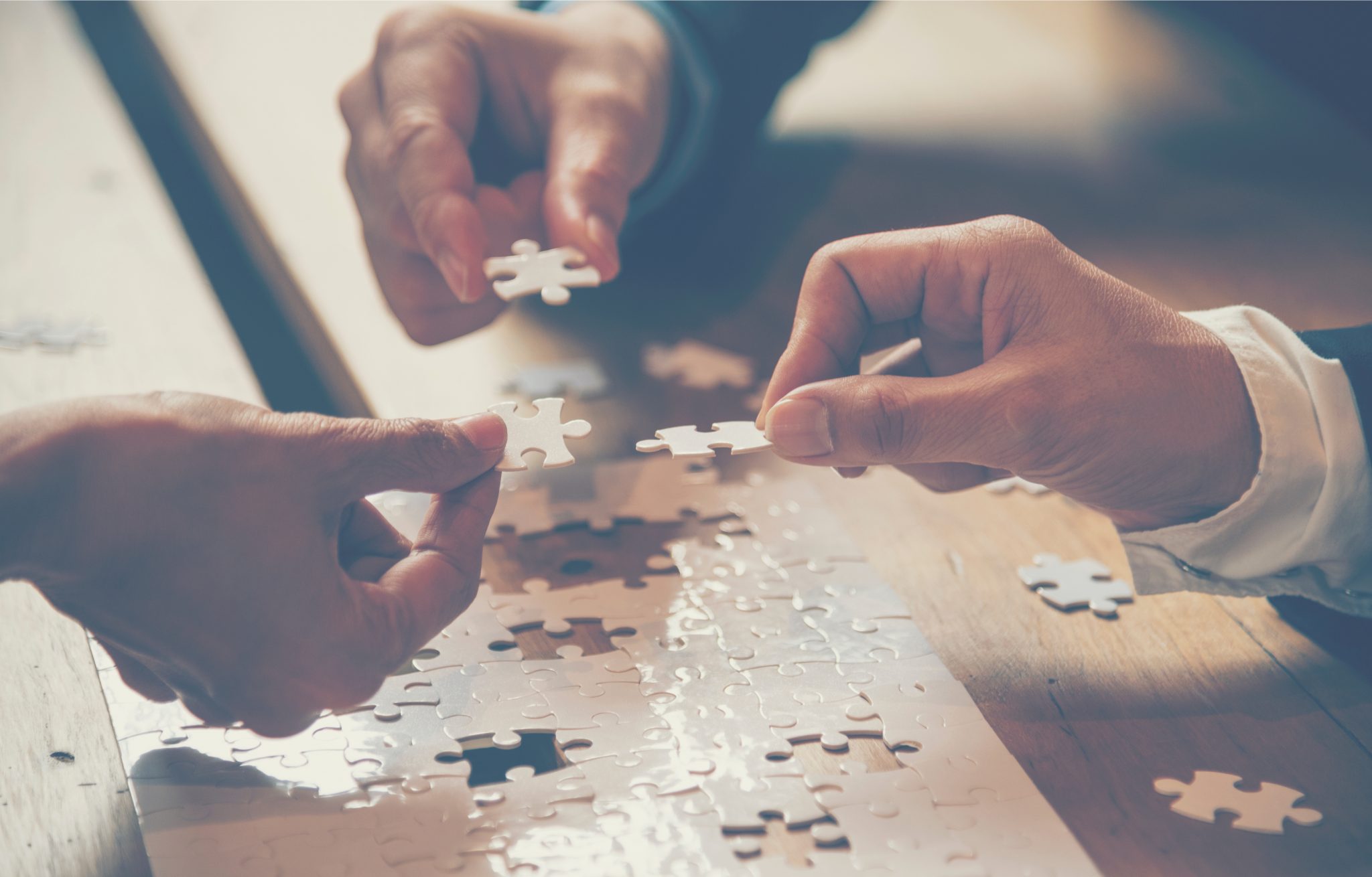 Many hands working together to create a jigsaw