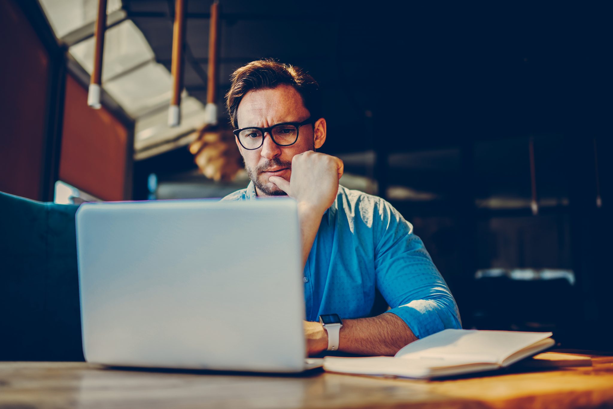 Male accountant working at a laptop in a well-presented meeting room
