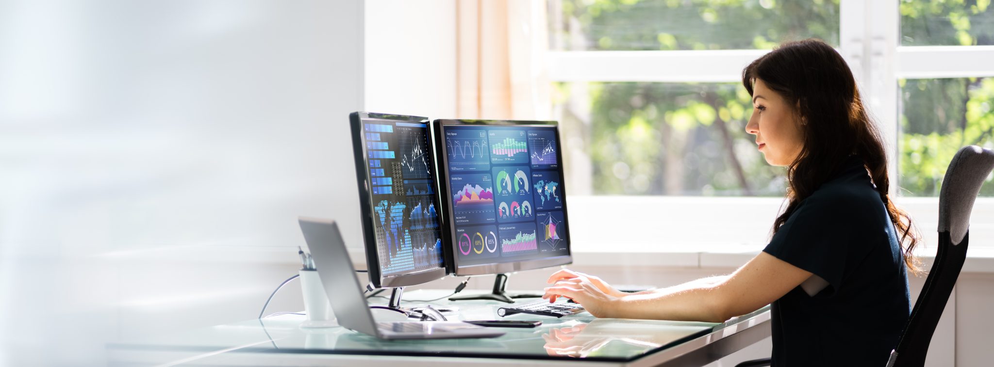 Woman working on two screens
