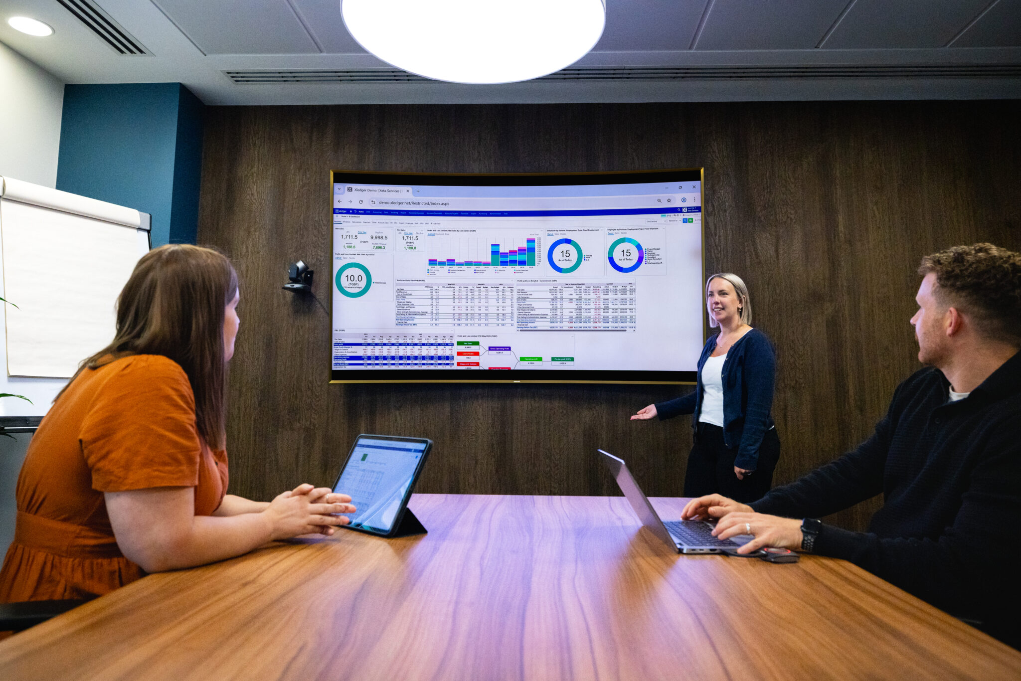 Woman presenting Xledger to two people