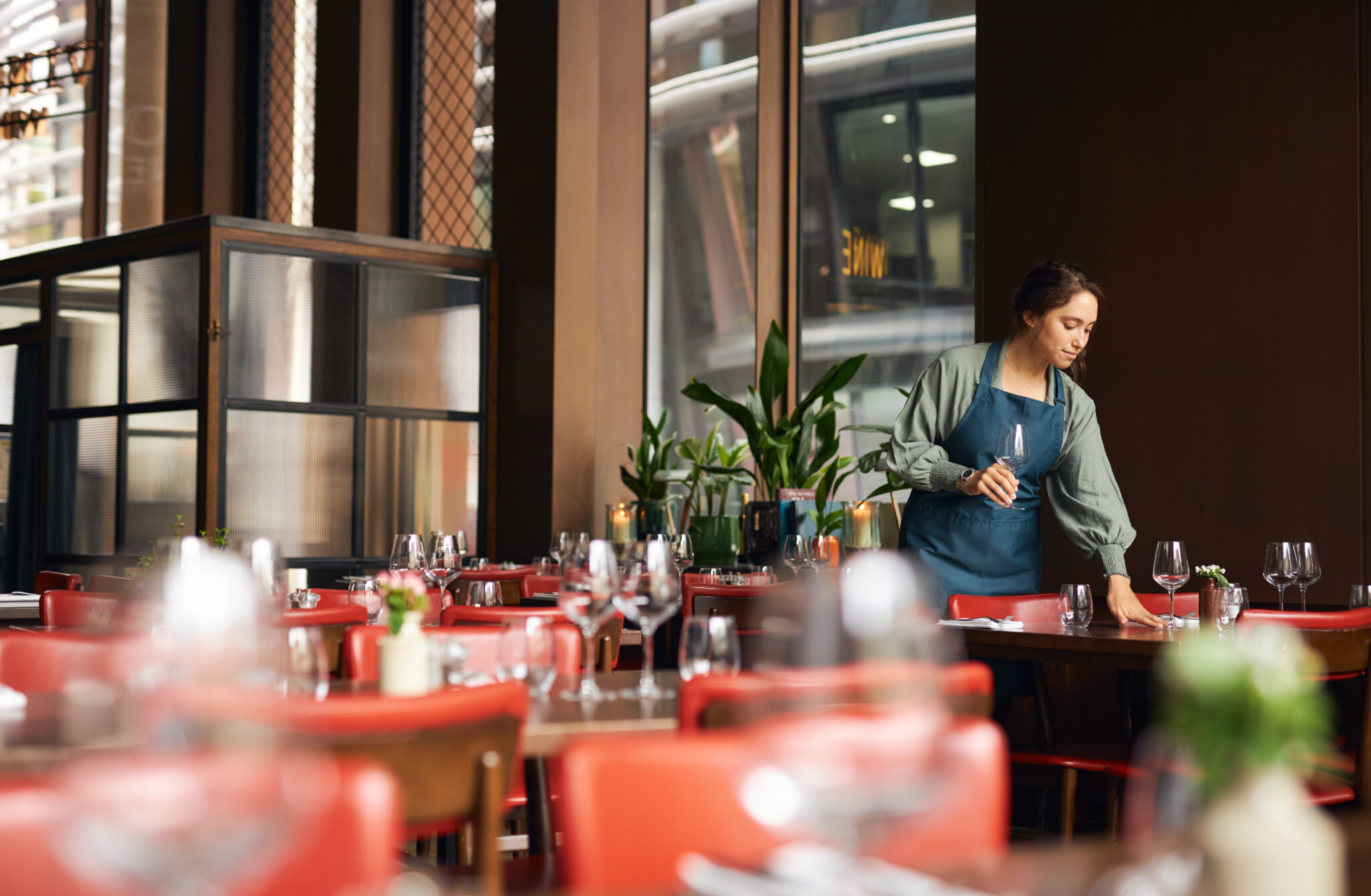 Female waitress setting tables in restaurant