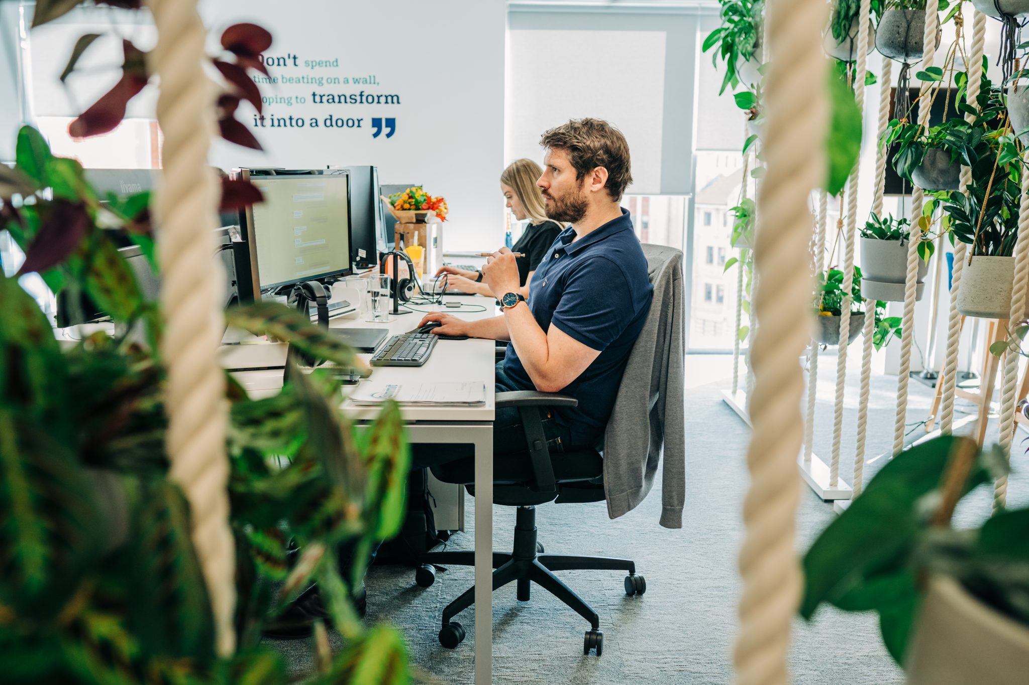 man on computer with plants around