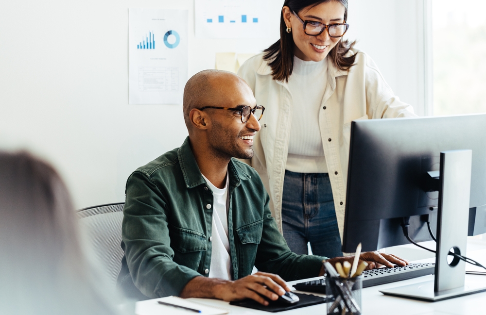 Man and woman looking at computer and smiling