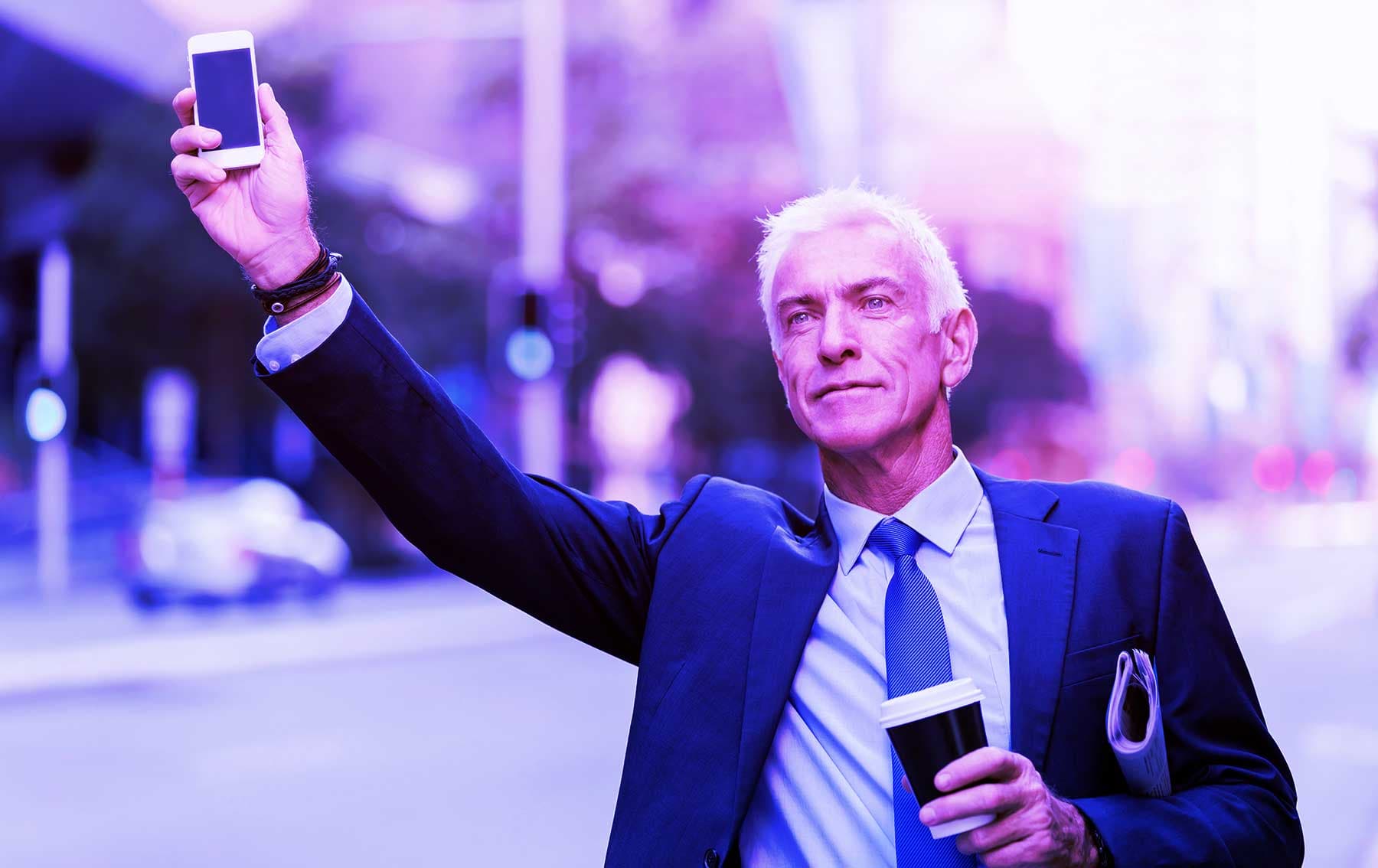 Businessman in a suit hailing a ride on a city street while holding up a smartphone, carrying a coffee cup and documents, with purple-blue lighting effects.