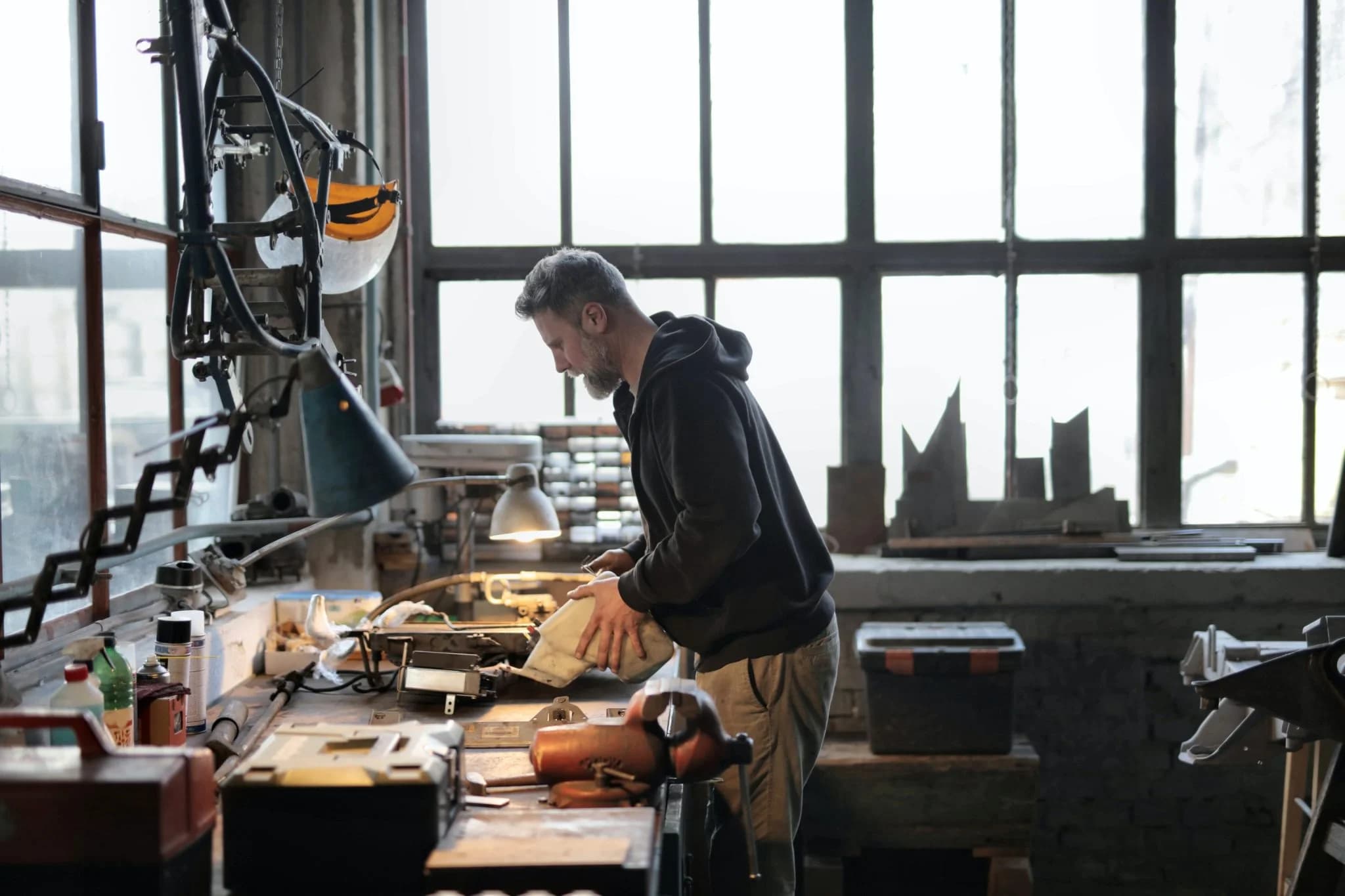 Man working at a workbench in a workshop with tools and equipment
