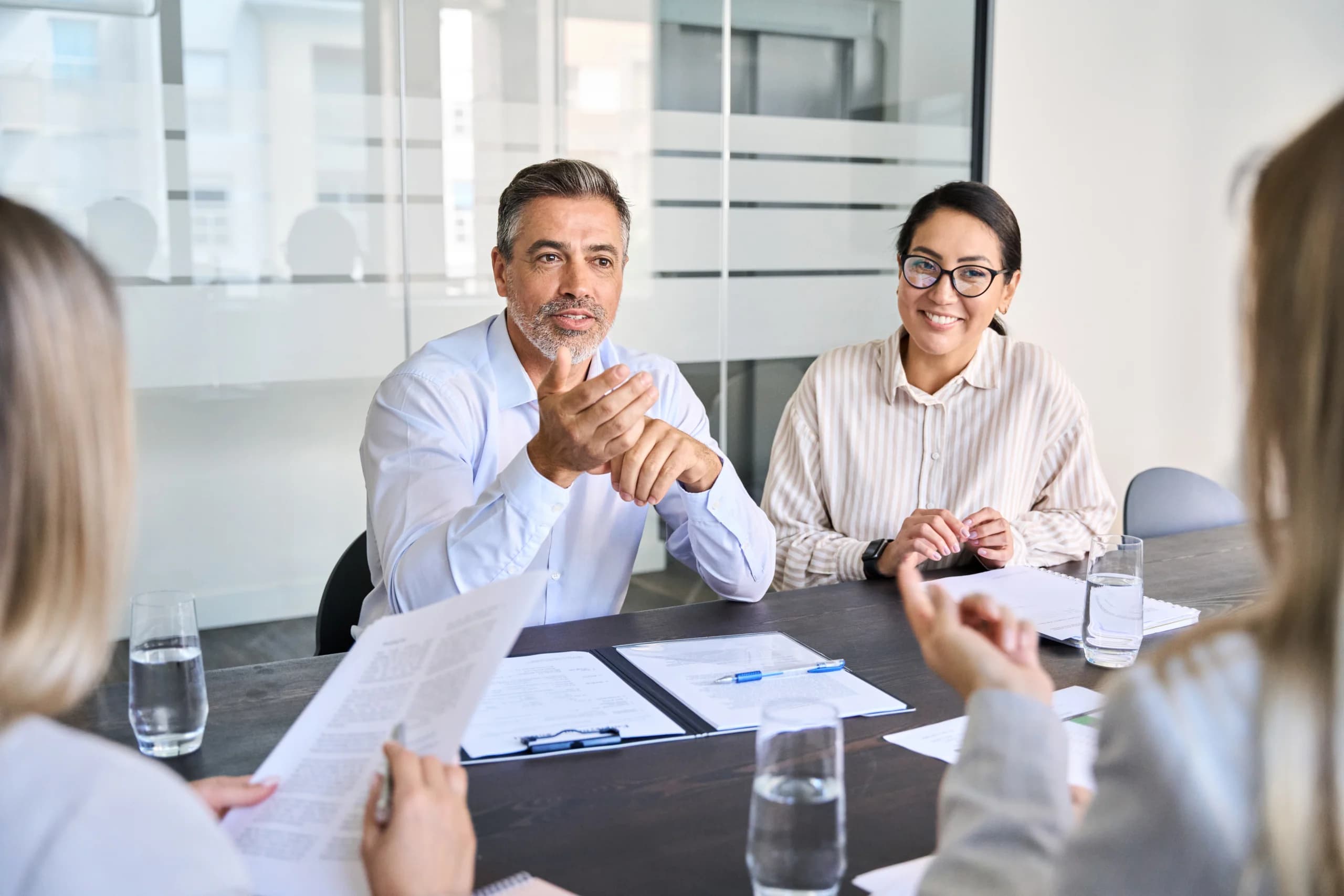 Business professionals discussing documents in a meeting room