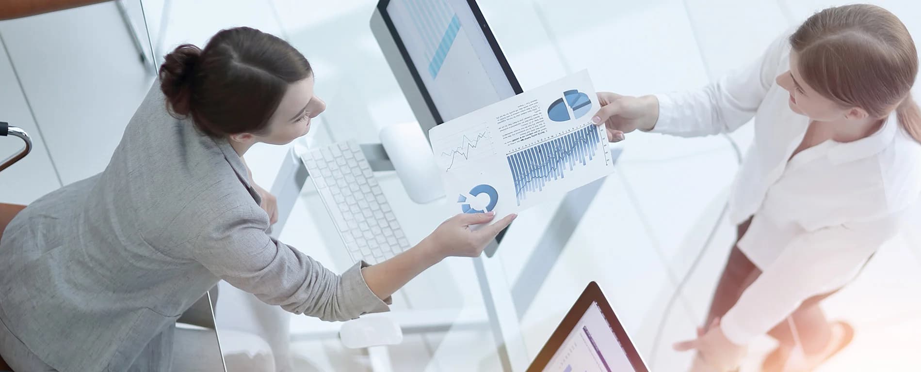 Two professionals reviewing charts and reports at a desk
